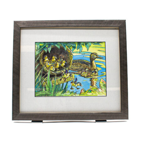 Framed artwork titled Mallard First Flight, showing a mallard duck on water with ducklings climbing from a nest into a wetland scene, surrounded by greenery and reflected light.